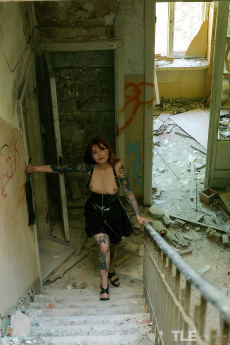 Redhead model Cherr explores abandoned building and pleasures herself with flogger